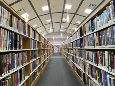 aisle shot in between rows of shelves of books